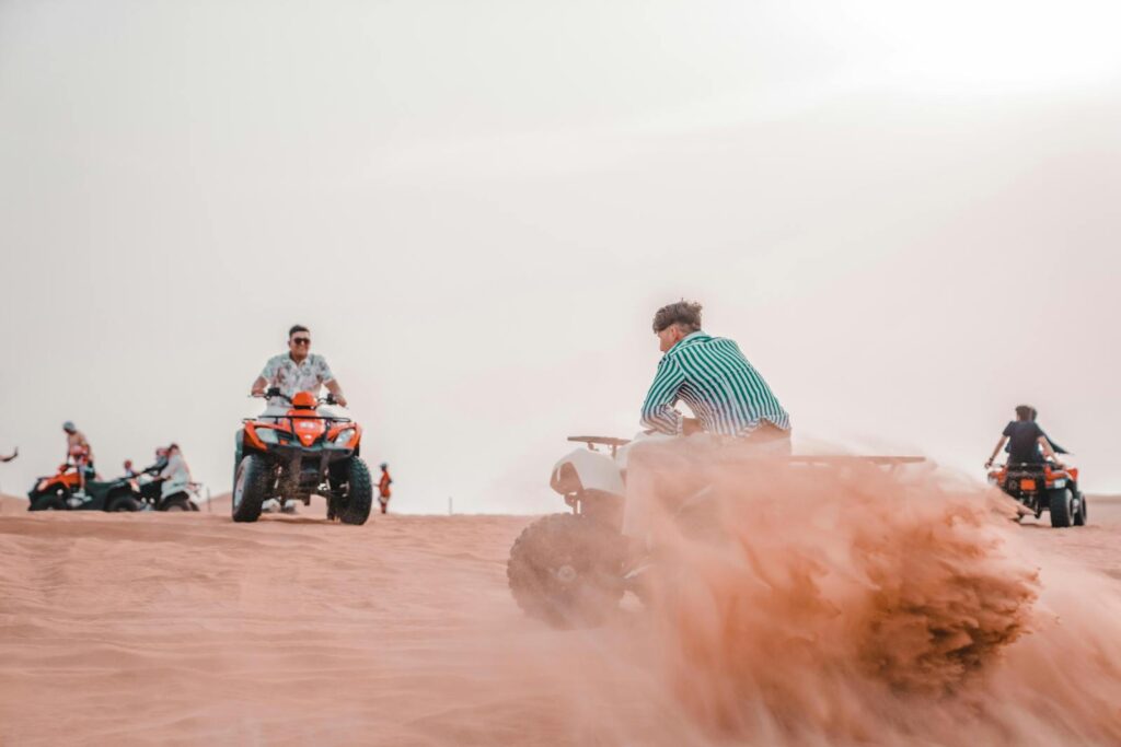 People Riding on Quad Bikes in the Desert