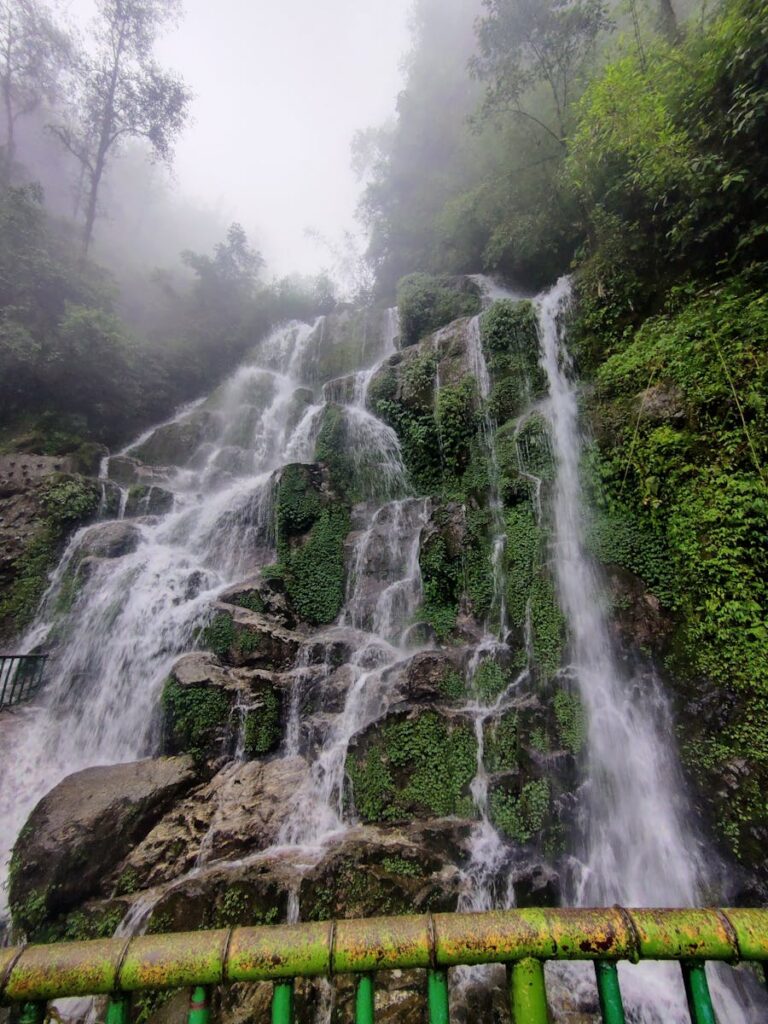 A stunning view of Bakthang Waterfall in Gangtok, cascading down lush green rocks.